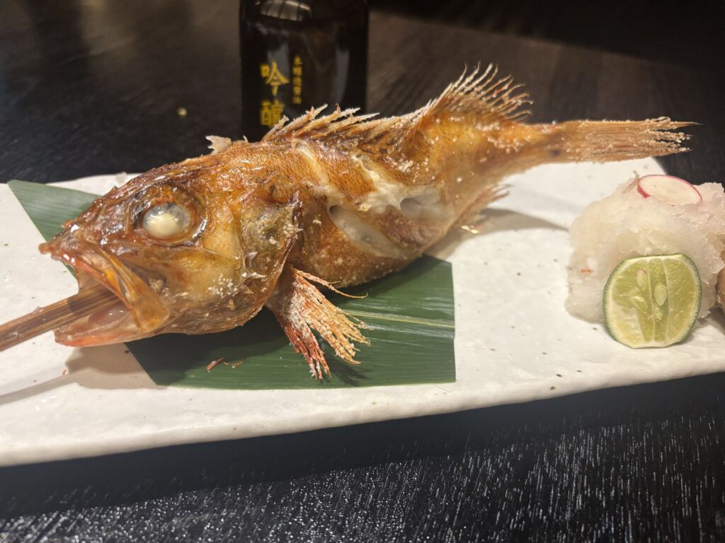 A whole salt-grilled nodoguro, head to tail, with grated daikon and sudachi