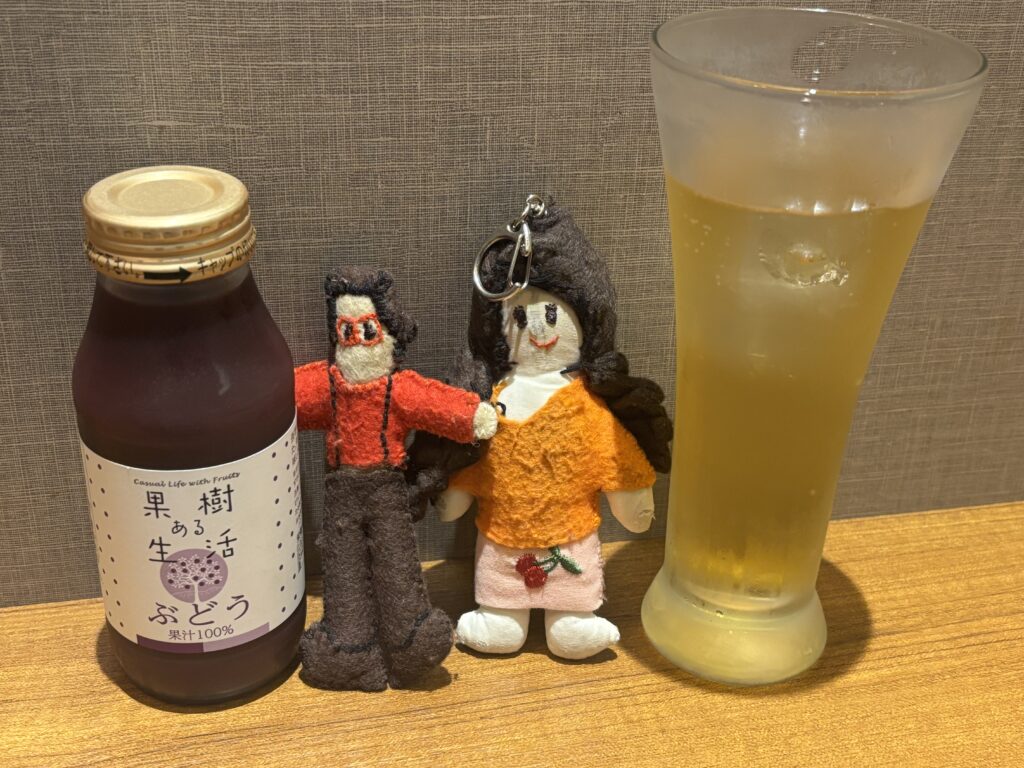 Tikoppi and Presley between a bottle of grape juice and a glass