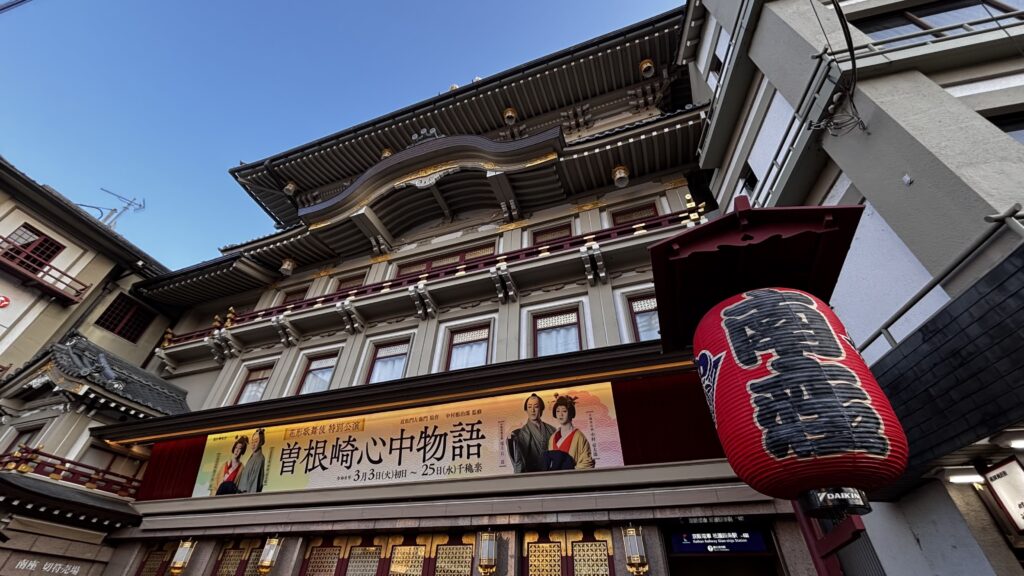 Minami-za from the street, with the banner for "The Love Suicides at Sonezaki" and the theatre's red lantern