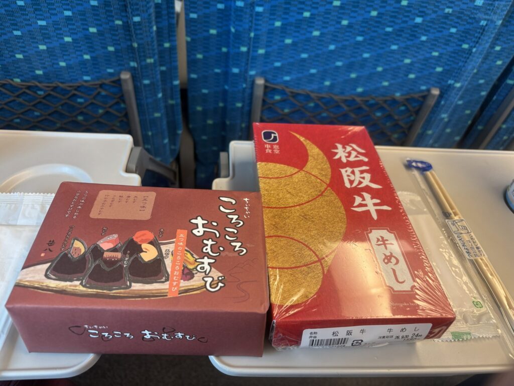 Matsusaka Beef Gyumeshi and Chiichai Korokoro Omusubi on a seat tray inside a display train